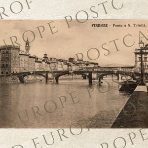 May include: Sepia-toned vintage postcard featuring the Ponte Santa Trinita bridge in Florence, Italy. The image shows the bridge over the Arno River, with buildings lining the riverbanks. The text "FIRENZE - Ponte a S. Trinità" is visible.