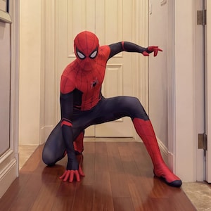 May include: A full-body Spiderman costume featuring a red and black color scheme with a web pattern on the red sections. The suit includes a mask with white eye lenses, a small spider emblem on the chest, and long sleeves with matching gloves.