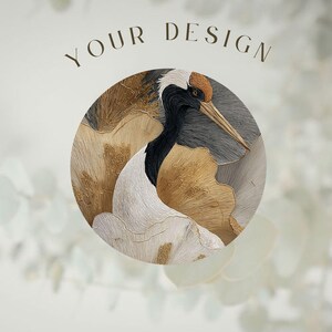 May include: A circular graphic featuring a detailed illustration of a red-crowned crane with black, white, and gold textured plumage. The text YOUR DESIGN is printed in a dark brown serif font above the circular artwork on a light background.