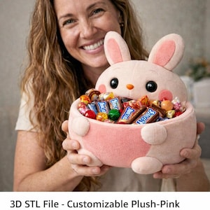 May include: A plush pink rabbit bowl filled with colorful candies. The bowl has a round shape with a bunny face and ears. The image also includes the text "3D STL File - Customizable Plush-Pink Rabbit Bowl | Cute Candy Holder | Easter Basket Design | 3D Printable STL File".