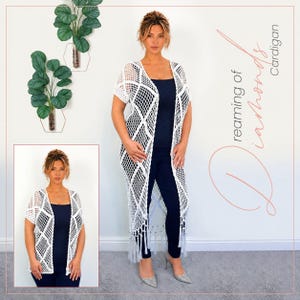May include: A long white crochet cardigan featuring a diamond-shaped openwork pattern, short sleeves, and a fringed hem. The garment is worn over a dark navy blue tank top and matching trousers. The text Dreaming of Diamonds Cardigan is visible.