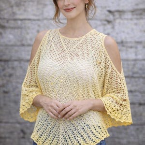 Peut inclure: Un haut en crochet jaune avec des épaules dénudées et des manches trois-quarts. Le haut a un design ample et aéré et est associé à un jean bleu. Le motif en crochet est visible sur tout le vêtement.