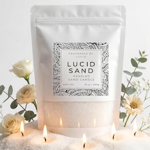 May include: A white pouch labeled "Lucid Sand" with a black and white decorative design. The pouch contains pearled sand and is surrounded by white flowers, greenery, and lit candles. The refill kit contains 16 oz / 454g of sand.
