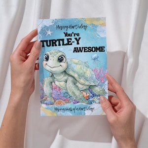 Op de afbeelding: Een rechthoekige verjaardagskaart met een illustratie van een zeeschildpad in een koraalrif. De tekst luidt Happy Birthday, You're TURTLE-Y AWESOME en Have a Shell of a Birthday! De achtergrond is voorzien van een lichtblauwe aquareltekening.