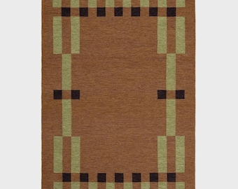 May include: A rectangular brown rug with a geometric design. The rug features a central brown field with a border of olive green and black rectangular shapes. The design creates a framed effect, suitable for home decor.