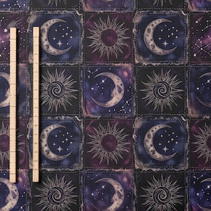 Może przedstawiać: Materiał z niebiańskim wzorem przedstawiającym księżyce, słońca i konstelacje w odcieniach fioletu, błękitu i złota. Dwie drewniane linijki umieszczono pionowo po lewej stronie obrazu.