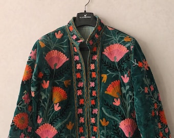 May include: A dark green velvet jacket with intricate floral embroidery in shades of pink, orange, and yellow. The jacket features a mandarin collar and is displayed on a hanger.