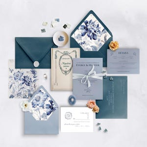 K&ouml;nnte beinhalten: Eine Auswahl an Hochzeitsbriefpapier in Blau- und Wei&szlig;t&ouml;nen. Enth&auml;lt Umschl&auml;ge, Karten und ein kleines Buch. Blumenmuster und der Text "EVERLY & HUNTER" sind zu sehen. Dekorative Elemente sind ein Band, Briefmarken und Blumen.