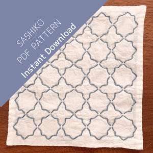 Könnte beinhalten: Ein weißes Stoffquadrat mit einem geometrischen Sashiko-Muster, das mit blauem Faden gestickt ist. Der Text "SASHIKO PDF PATTERN Instant Download" befindet sich in einem blauen diagonalen Banner in der oberen linken Ecke. Das Muster ist eine sich wiederholende Reihe verbundener Formen.