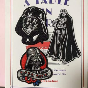 May include: Three embroidered patches featuring Darth Vader from Star Wars. One patch shows Vader's helmet, another shows his full figure, and the third has a red background with the words "Dark Side". The patches are black, white, and red.