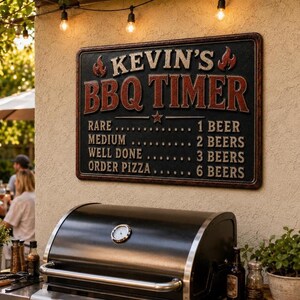 May include: A rectangular black wall sign with a weathered red border and white text reading KEVIN'S BBQ TIMER. The sign lists cooking levels from rare to well done with corresponding beer counts, plus an order pizza option for six beers.