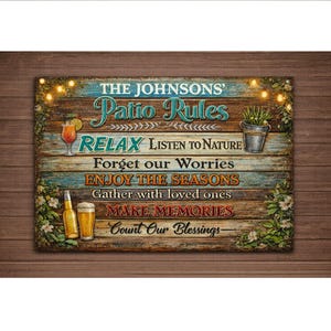 May include: A rectangular wooden sign with the text "THE JOHNSONS' Patio Rules" in a decorative font. The sign includes phrases like "RELAX" and "MAKE MEMORIES", along with images of a cocktail, beer, and a potted plant. The sign is decorated with string lights and floral accents.
