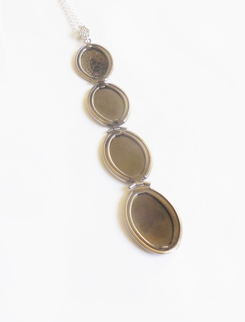 Puede incluir: Un collar de cadena de plata con un colgante de medall&oacute;n. El medall&oacute;n tiene cuatro compartimentos ovalados que se abren para revelar espacios vac&iacute;os para fotos o recuerdos.