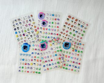 Könnte beinhalten: Vier transparente Aufkleberbögen mit zahlreichen kleinen, bunten Charakter-Icons und fünf größeren, kreisförmigen Illustrationen von digitalen Haustierspielzeugen in Blau, Lila, Pink und Grün, angeordnet in einem fächerartigen Muster.