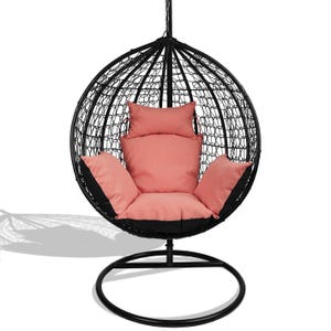 Könnte beinhalten: Ein schwarzer, hängender Eiersessel mit gewebtem Rahmen und kreisförmiger Basis. Der Stuhl hat korallenfarbene Kissen und Kissen mit schwarzen Akzenten. Der Stuhl ist für die Entspannung im Freien oder in Innenräumen konzipiert.