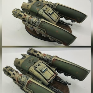 Peut inclure: Maquette détaillée d'un avion militaire, avec une palette de couleurs vert olive, beige et marron. Le modèle présente des détails complexes, notamment des armes et des composants de moteur. Le modèle est monté sur une base marron. Le logo "COG WORKS" est visible.