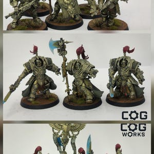 May include: Miniature figurines of armoured warriors with red plumes, holding weapons and shields. The figures are painted in metallic gold and green tones, with blue accents on the weapons. The logo "COG WORKS" is visible.