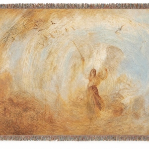 May include: A woven throw blanket featuring a classical painting of an angel with outstretched arms, holding a staff. The artwork is in shades of beige, brown, and blue, with a black fringe border.