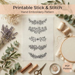May include: A printable hand embroidery pattern featuring floral designs. The designs are displayed on a cream-colored fabric, with embroidery tools, thread spools, and a wooden embroidery hoop. The text "Printable Stick & Stitch" is at the top.