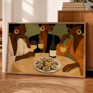 Peut inclure: Une impression d'art horizontale encadrée représentant trois personnes à la peau foncée assises autour d'une table ronde. Elles portent des créoles dorées et des lunettes de soleil, avec des verres de vin blanc et une assiette d'huîtres.