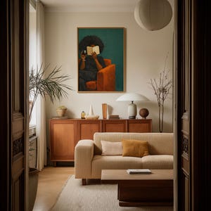 May include: A living room featuring a beige textured sofa with two throw pillows, a wooden coffee table, and a wooden sideboard. Above the sideboard hangs a framed painting of a person reading a book while holding a glass of wine in an orange chair.
