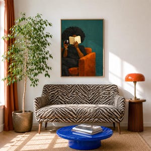 May include: A living room scene featuring a zebra-print sofa, a glossy blue round coffee table with stacked books, a tall potted ficus tree, and an orange mushroom-style lamp on a fluted side table. A framed painting hangs above the sofa.