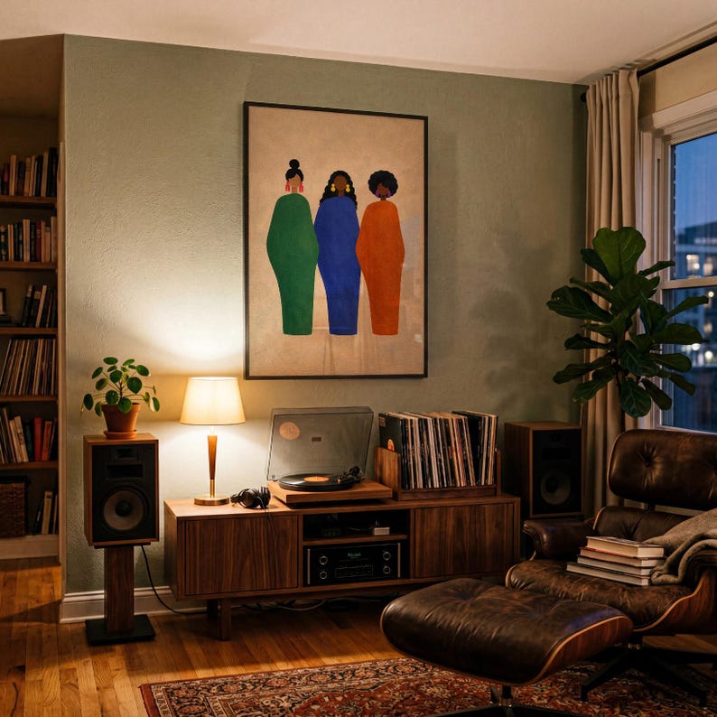 May include: A cozy living room scene with a mid-century modern aesthetic. Features a framed artwork with three figures in green, blue, and orange. A record player, speakers, and a leather armchair complete the setup. A lamp and a potted plant add warmth.