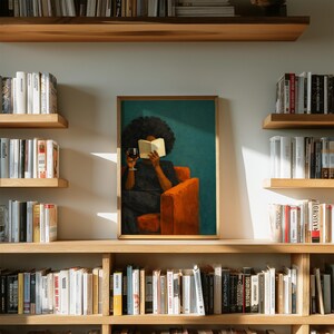 May include: A framed wall art print featuring a person with dark curly hair sitting in a bright orange armchair, reading an open book while holding a glass of red wine. The background is a solid teal color, and the print is displayed on a wall.
