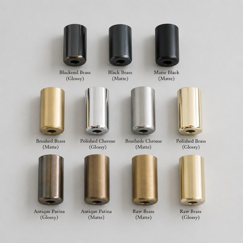 May include: A collection of eleven cylindrical metal hardware knobs arranged in three rows. Finishes include Blackened Brass, Black Brass, Matte Black, Brushed Brass, Polished Chrome, Brushed Chrome, Polished Brass, Antique Patina, and Raw Brass.