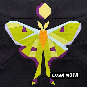 May include: A geometric design of a Luna moth on a black background. The moth features lime green, orange, purple, and light blue accents. The text "LUNA MOTH" is in a white font.