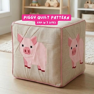 May include: A beige cube-shaped ottoman with pink trim and two appliqued pink pigs. The text "PIGGY QUILT PATTERN" and "FPP IN 3 SIZES" are displayed on the top. The pig designs are geometric and modern.