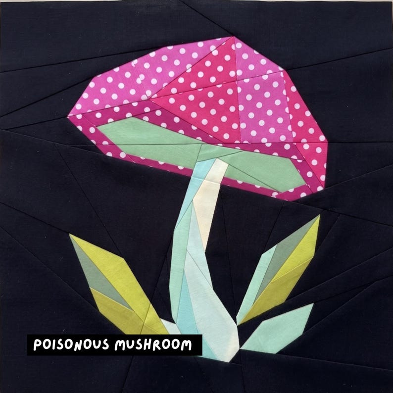 May include: A fabric art piece featuring a stylized mushroom with a pink polka-dot cap, green underside, and a light blue stem. The mushroom is set against a black background with the text "POISONOUS MUSHROOM" in white.