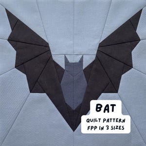 Puede incluir: Un bloque de edredón geométrico con un diseño de murciélago. El murciélago tiene alas grises oscuras y un cuerpo gris claro, sobre un fondo azul claro. El texto "BAT" y "QUILT PATTERN FPP IN 3 SIZES" se muestra en un rectángulo blanco.