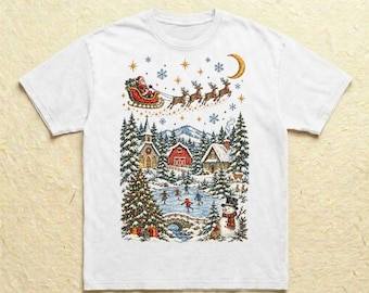 Könnte beinhalten: Ein weißes Kurzarm-T-Shirt mit einer farbenfrohen Grafik einer winterlichen Dorfszene. Der Druck zeigt den Weihnachtsmann im Rentierschlitten, eine verschneite Landschaft mit Häusern, einen geschmückten Weihnachtsbaum und einen Schneemann.