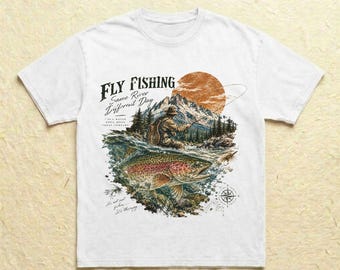 Könnte beinhalten: Ein weißes Kurzarm-T-Shirt mit einem Grafikdruck einer Person beim Fliegenfischen in einem Fluss, mit Bergen und einer großen orangefarbenen Sonne im Hintergrund. Der Text lautet Fly Fishing, Same River Different Day und It's therapy.