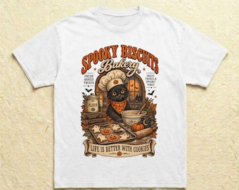 Könnte beinhalten: Ein weißes T-Shirt mit einer Grafik eines schwarzen Katers, der eine Kochmütze und ein orangefarbenes Bandana trägt. Der Text lautet SPOOKY BISCUITS BAKERY, FRESH BAKED TREATS, SWEET THINGS & SPOOKY VIBES und LIFE IS BETTER WITH COOKIES, mit Keksen.