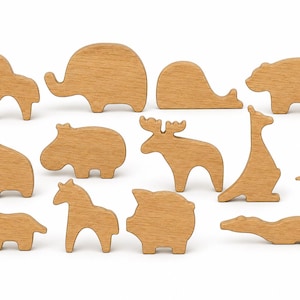Könnte beinhalten: Eine Sammlung von zwölf hellbraunen Tierfiguren aus Holz, darunter Formen von Pferd, Elefant, Wal, Bär, Giraffe, Flusspferd, Elch, Känguru, Dinosaurier, Schwein und Krokodil, alle mit glatten Oberflächen und einfachen Silhouetten.