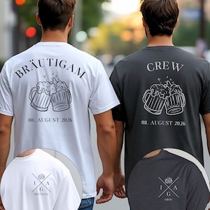 K&ouml;nnte beinhalten: Ein wei&szlig;es T-Shirt mit dem Text BR&Auml;UTIGAM und einer Bierkrug-Grafik &uuml;ber 08. AUGUST 2026 sowie ein dunkelgraues T-Shirt mit dem Text CREW und einer Bierkrug-Grafik &uuml;ber 08. AUGUST 2026. Beide Shirts zeigen ein kleines Brustlogo mit J A G.