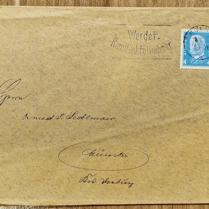 Peut inclure: Enveloppe beige avec texte manuscrit et un timbre-poste bleu. Le timbre porte un portrait et le chiffre 4. L'enveloppe porte la mention "Werdet. Rundfunkteilnehmer" et la ville "Münster" est également écrite sur l'enveloppe.