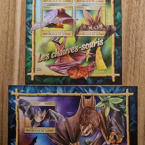 Op de afbeelding: Twee postzegelvellen met vleermuisillustraties. De postzegels zijn omlijst met bamboe-achtige randen en bevatten Franse tekst. De postzegels tonen verschillende vleermuissoorten, met coupures van 10000 FG en 40000 FG.