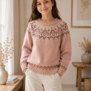 Può includere: Un maglione a maniche lunghe con girocollo in una delicata tonalità rosa polvere. Il capo presenta un motivo dettagliato e intricato nei toni del marrone scuro e crema attorno allo sprone e lungo l'orlo a coste. Il maglione ha una classica trama a maglia.