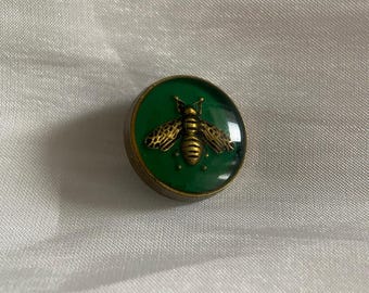 Green enamel button featuring an antique gold-tone bee design.