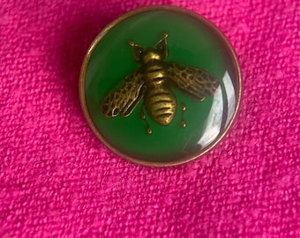 Green enamel button featuring an antique gold-tone bee design.