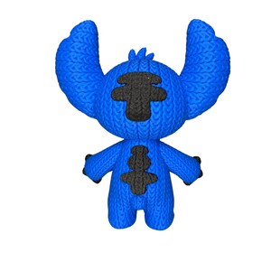 May include: A blue plush toy of a cartoon character with large ears and black accents. The toy has a knitted texture and is standing upright against a white background. The character's arms are outstretched, and it has a friendly expression.