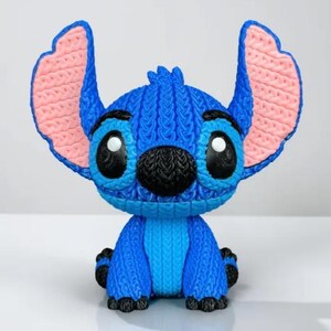 May include: A blue Stitch figurine with large ears, black eyes, and a black nose. The ears are pink inside. The figurine is sitting down with its arms and legs in front. The figurine is a character from the Disney movie Lilo & Stitch.