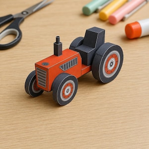 May include: A paper craft model of a tractor featuring a bright orange body, a black seat, and black wheels with orange centres. The tractor has a small black exhaust pipe on the bonnet and a front grille design printed on the orange paper surface.
