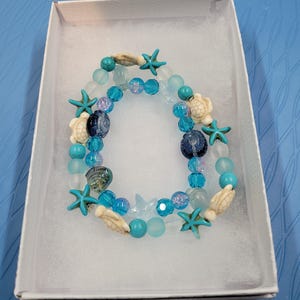 Conjunto de pulsera y tobillera con diseño de tortugas marinas y playa, elaborados a mano.
