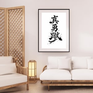 May include: Black framed art print featuring Japanese calligraphy in bold black ink on a white background. The artwork showcases vertical characters with expressive brushstrokes, creating a striking visual contrast. The print is displayed in a modern interior setting.