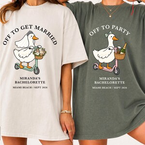 May include: Two oversized t-shirts, one cream and one green, feature a cartoon duck riding a scooter. The cream shirt says "Off to Get Married" and the green shirt says "Off to Party". Both shirts have "Miranda's Bachelorette" and "Miami Beach / Sept 2026" printed below.