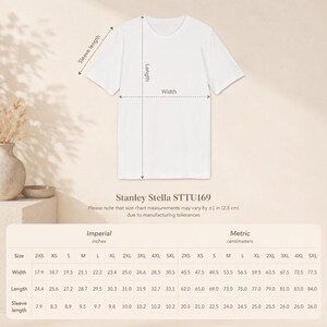 May include: A white t-shirt displayed with a size chart labeled Stanley Stella STTU169. The chart includes columns for width, length, and sleeve length in inches and centimeters, noting that measurements may vary by &plusmn;1 inch or 2.5 cm.